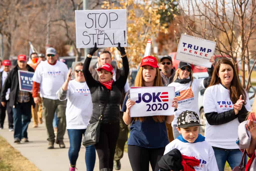 Pro Trump supporters at Stop the Steal rally holding signs against the media declaring Joe Biden President elect due to voter fraud and vote count being incomplete